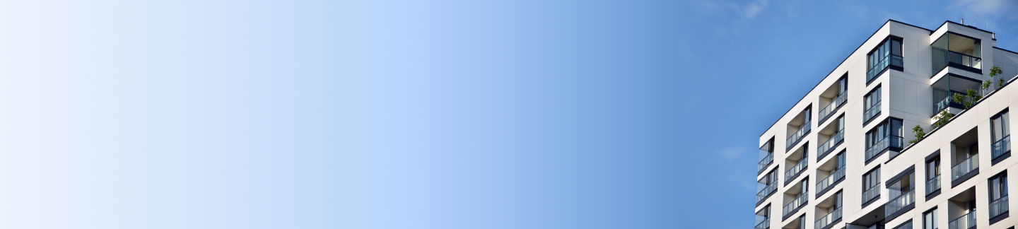A white apartment building with a blue sky and ombre background