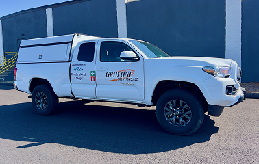 White truck with Grid One Solutions, LLC and Contractor For: Rhode Island Energy decals